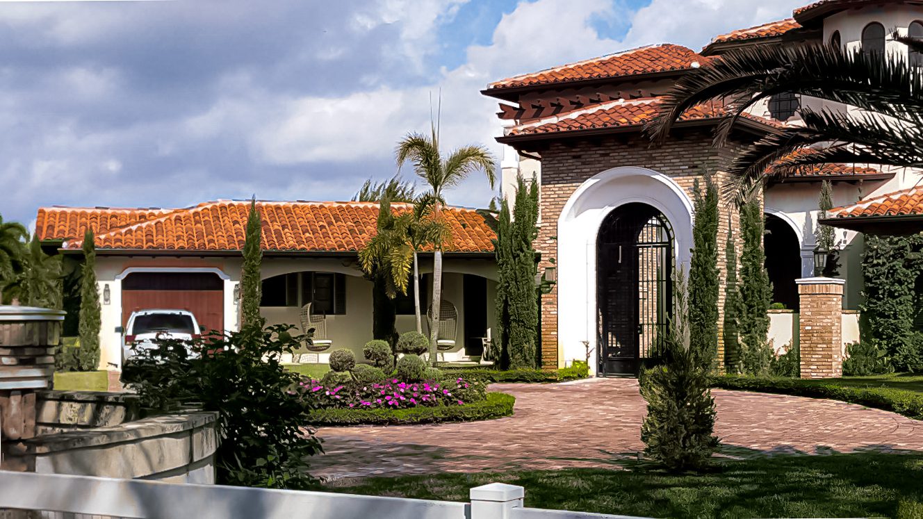 An image of a mediterranean style home with a driveway.
