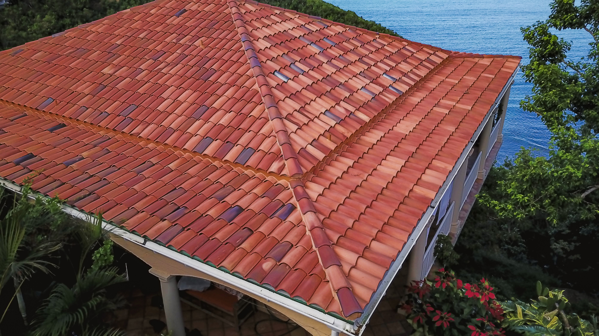 A house with a red tile roof near the ocean.