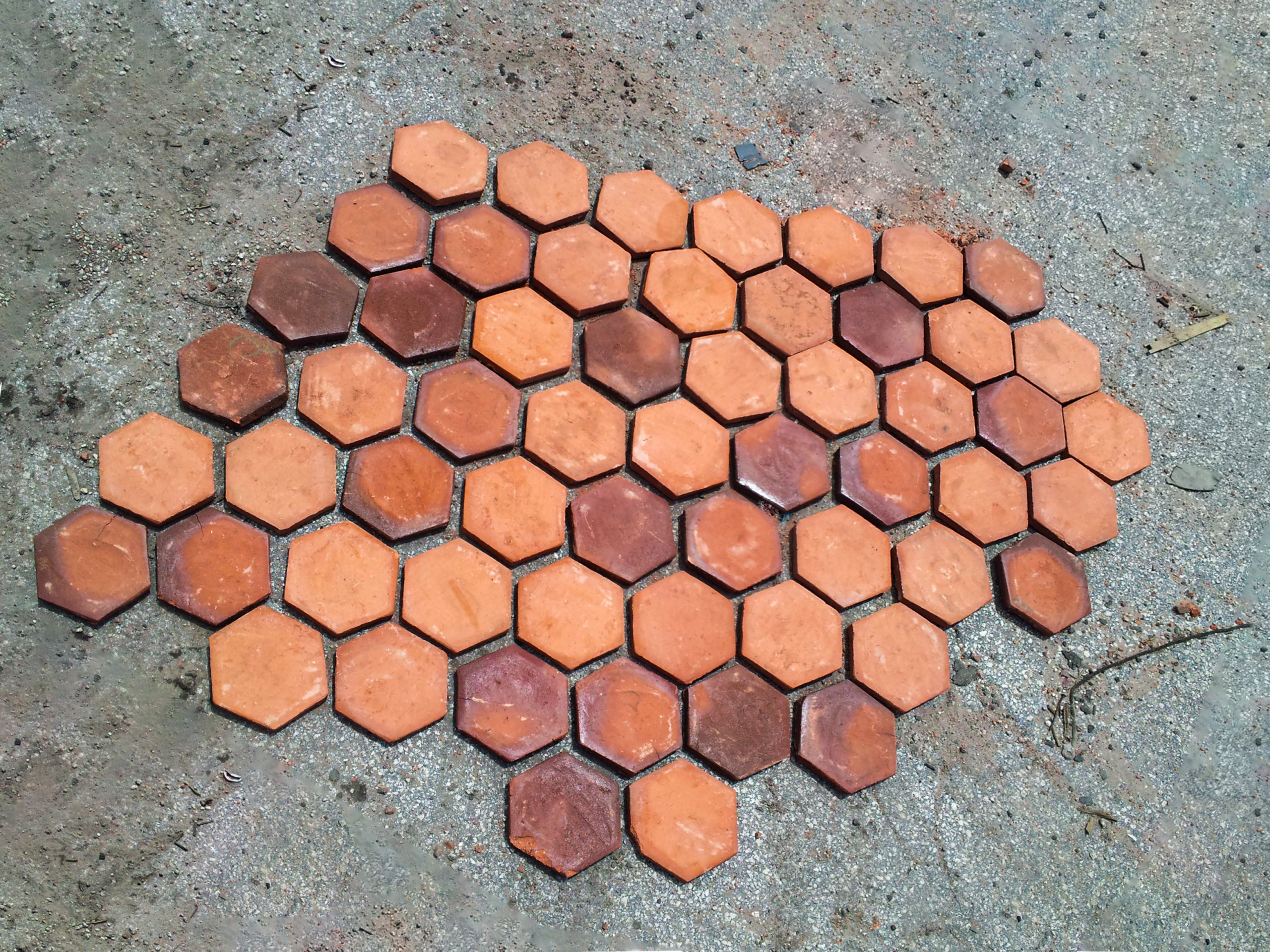 A group of orange hexagon tiles laid out on the ground.